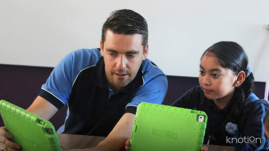 Un maestro está mostrando algo a su alumna en el iPad