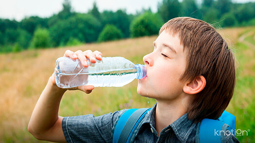 Un niño bebiendo agua de una botella