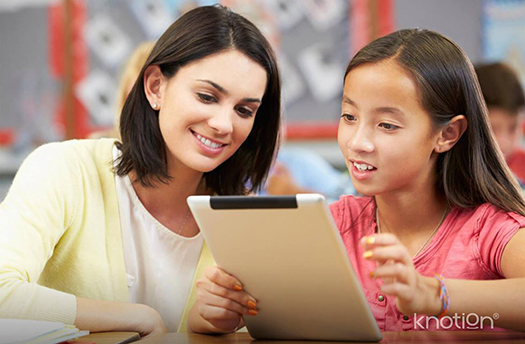 Un maestra apoyando a su alumna con una lección en el iPad