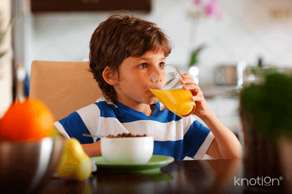 Un niño tomando jugo de naranja